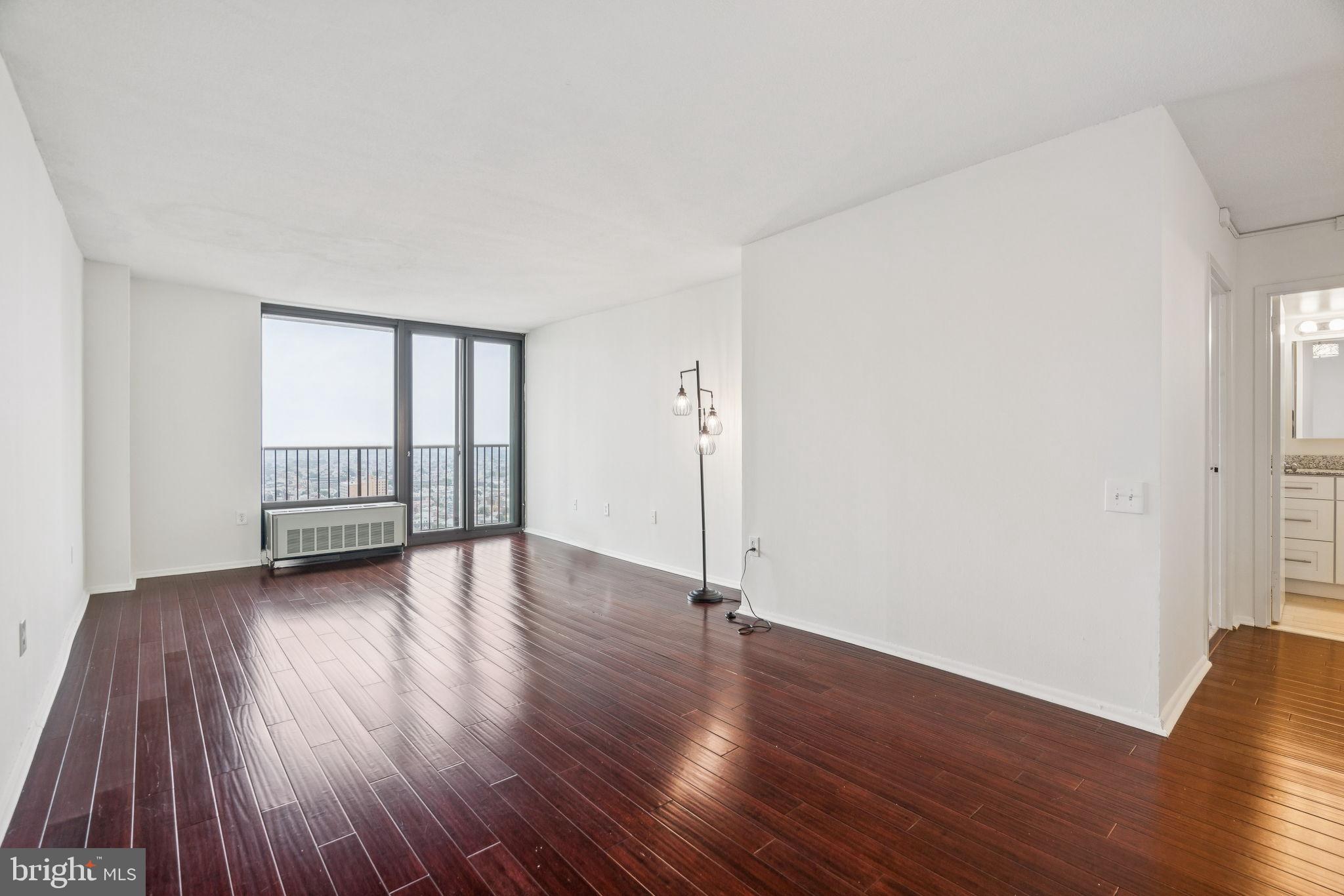 1420 Locust Street, Unit 28P Philadelphia, PA 19102 - Photo 3 of 25 an empty room with wooden floor and windows