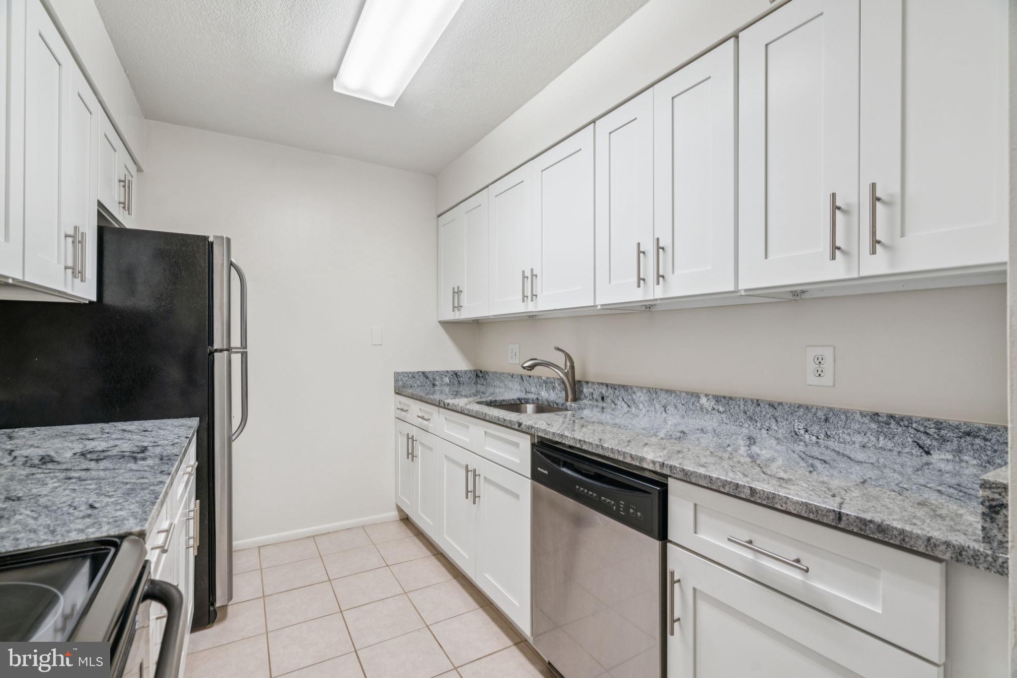 1420 Locust Street, Unit 28P Philadelphia, PA 19102 - Photo 7 of 25 a kitchen with stainless steel appliances granite countertop a stove and a refrigerator