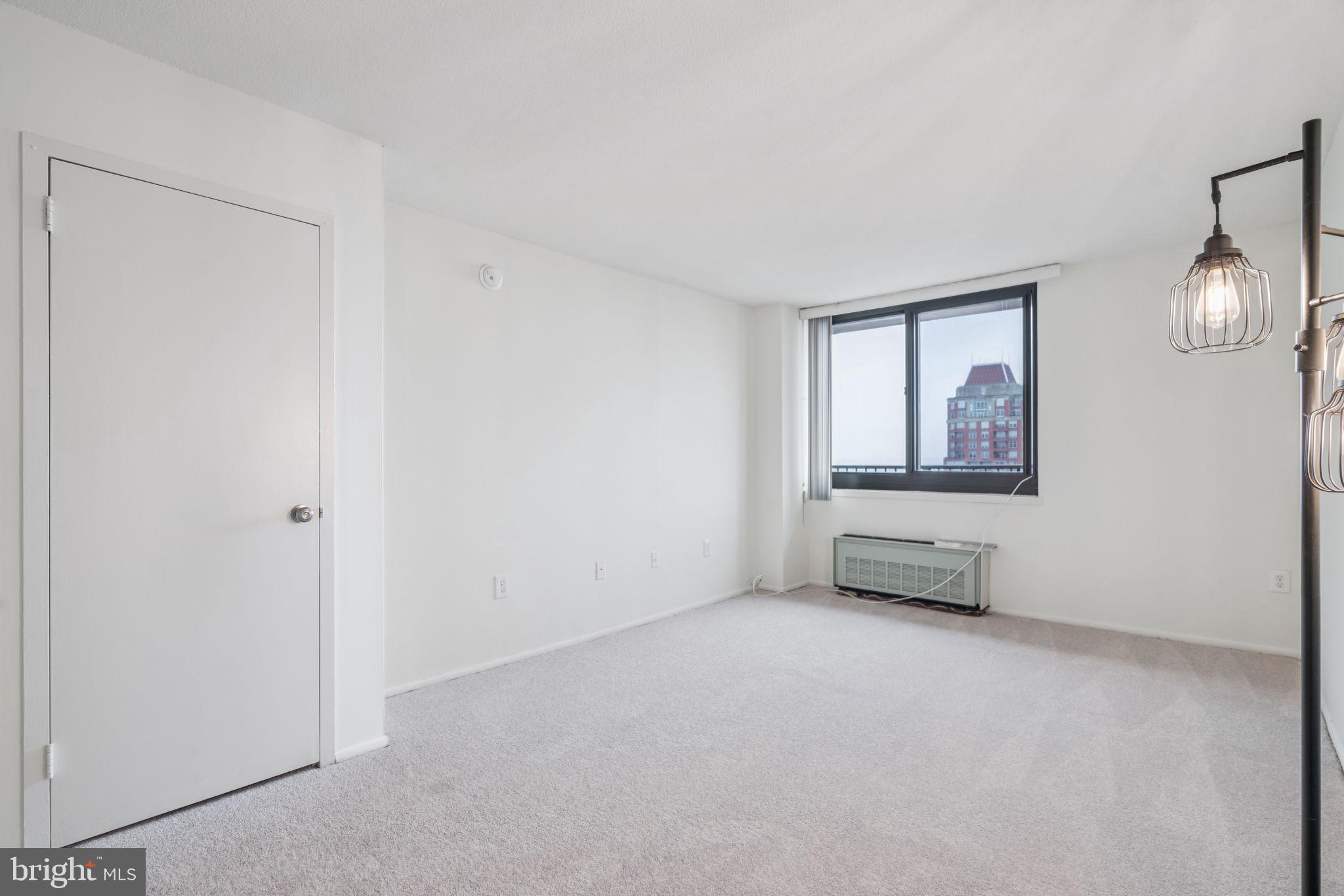 1420 Locust Street, Unit 28P Philadelphia, PA 19102 - Photo 10 of 25 an empty room with windows and mirror