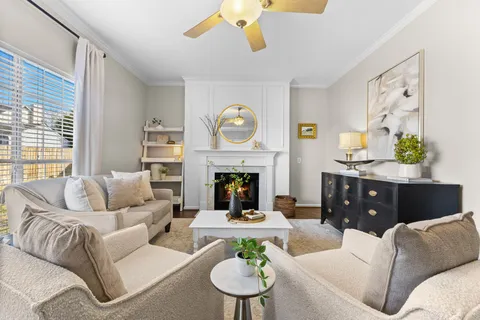 a living room with furniture a fireplace and a large window