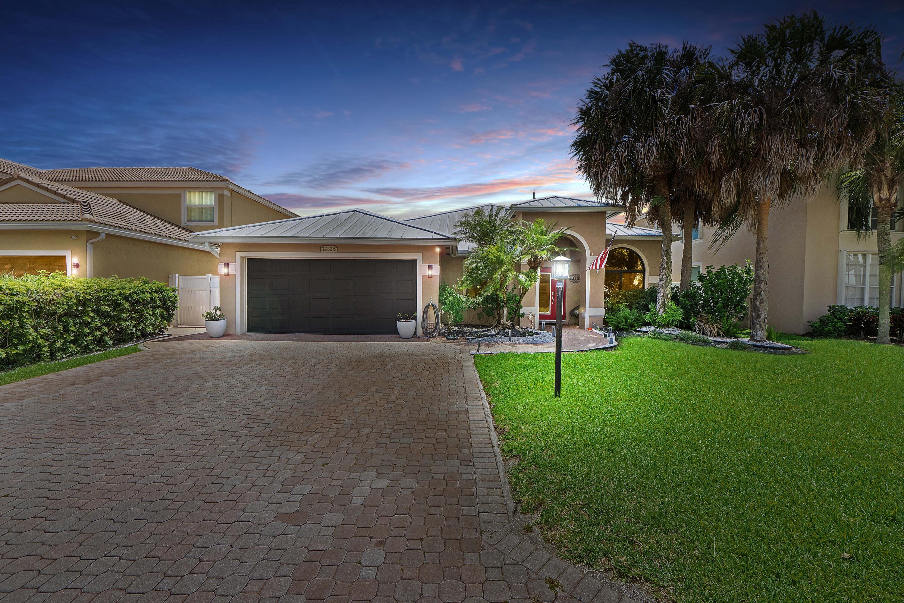 12328 St Simon Drive Boca Raton, FL 33428 - Photo 1 of 52 a front view of a house with a yard and a garage