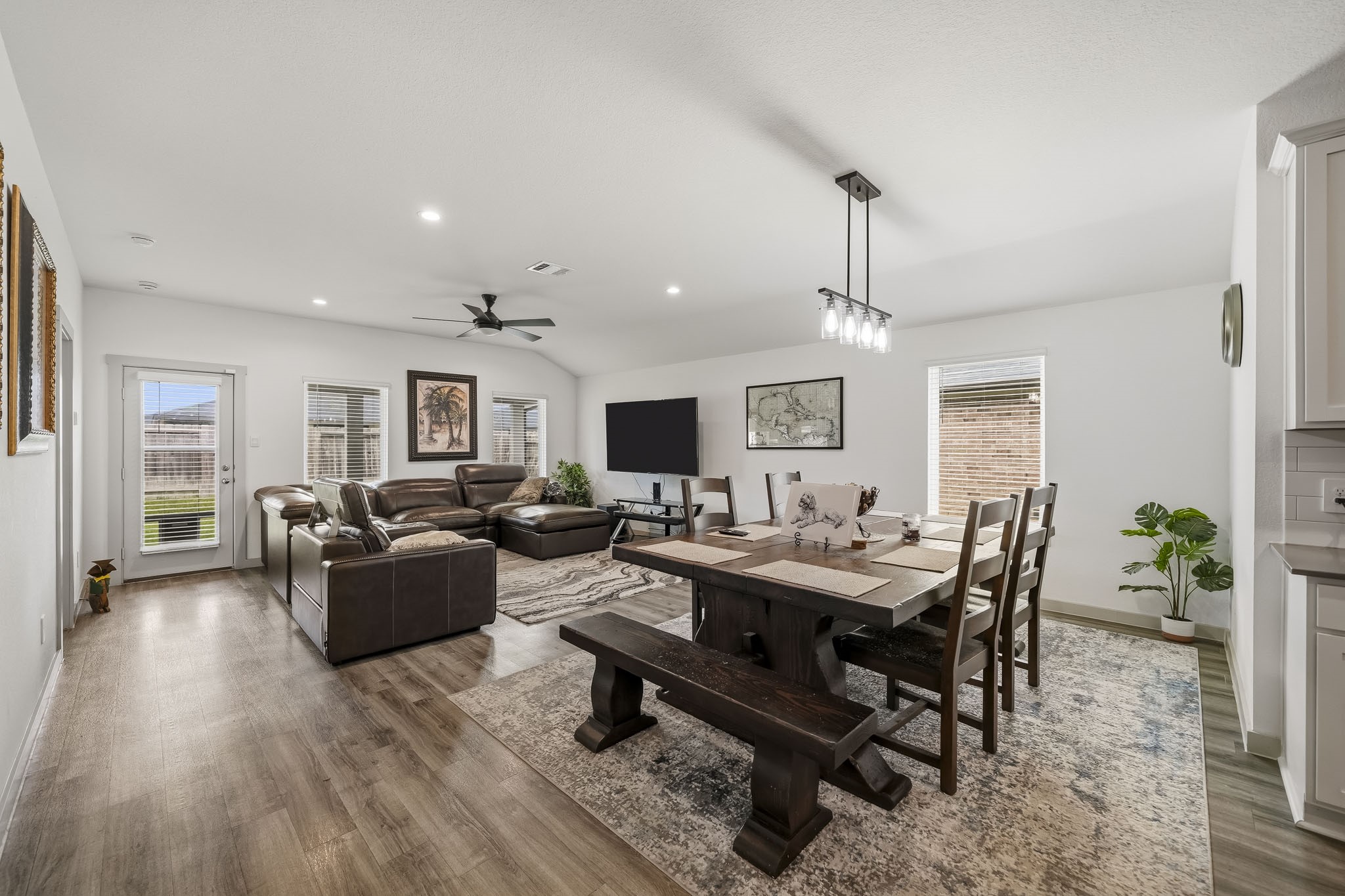 919 Tall Shire Court Rosharon, TX 77583 - Photo 8 of 19 This expansive open-concept layout seamlessly joins the dining area and main living room. A linear chandelier, recessed lighting, and large windows fill the continuous wood-look flooring with light.