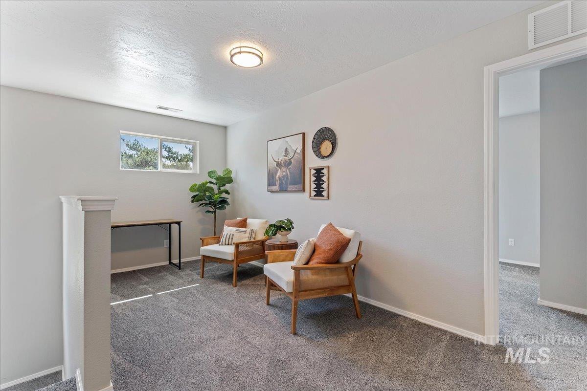 777 South Flintstone Avenue Meridian, ID 83642 - Photo 27 of 38 Living area with carpet and a textured ceiling