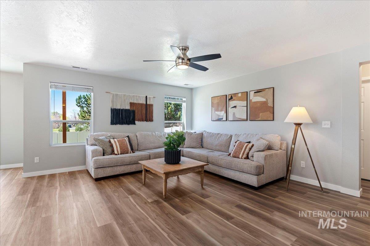 777 South Flintstone Avenue Meridian, ID 83642 - Photo 7 of 38 Living room featuring wood finished floors, ceiling fan, and a textured ceiling