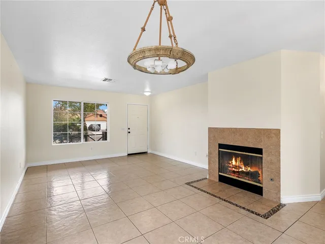 a view of an empty room with a fireplace and a window