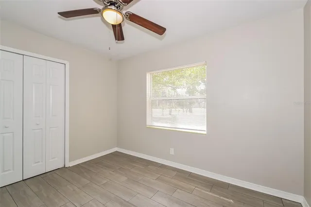 an empty room with a window and a fan