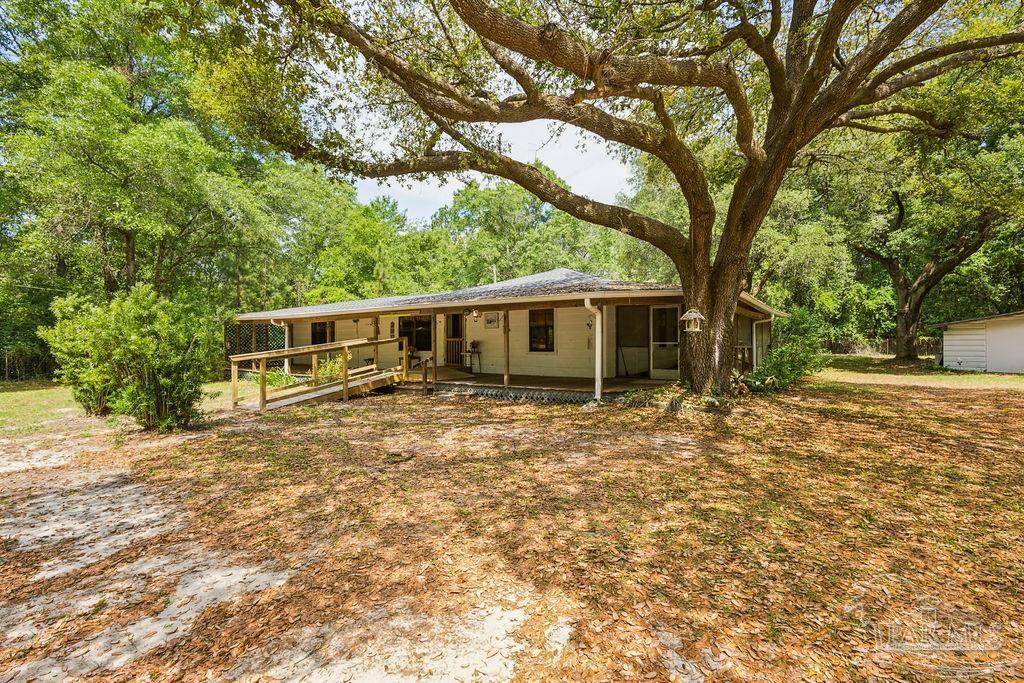 8938 Pioneer Road Holt, FL 32564 - Photo 1 of 44 front view of a house with a large tree