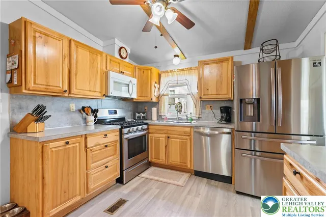 a kitchen with stainless steel appliances granite countertop a sink and a refrigerator