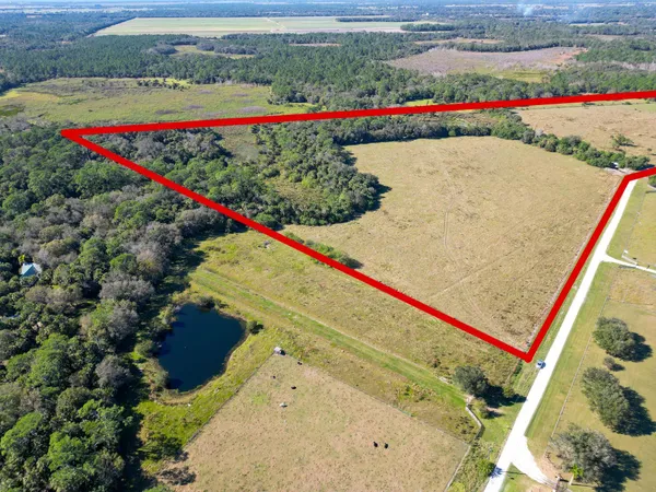 an aerial view of a house with a yard and lake view
