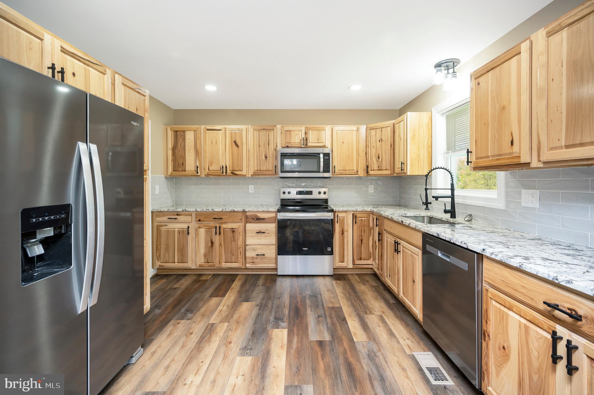 13452 Post Oak Road Spotsylvania, VA 22551 - Photo 24 of 56 a kitchen with stainless steel appliances granite countertop a refrigerator a stove a sink and a microwave