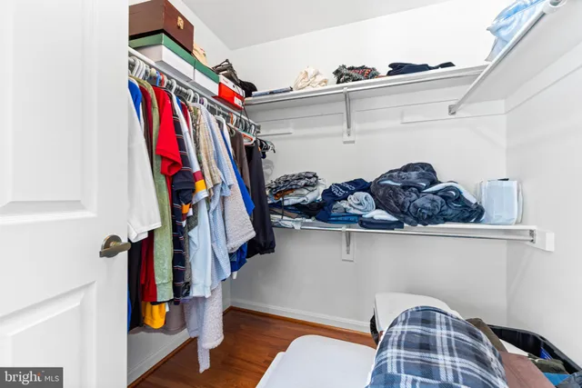 a view of walk in closet with clothes and shoes
