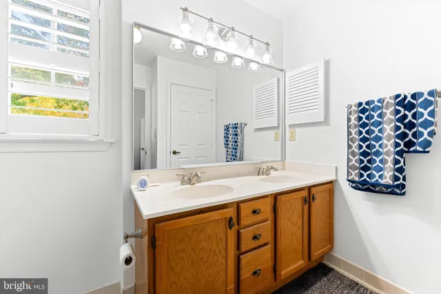 a bathroom with a sink a mirror and a window