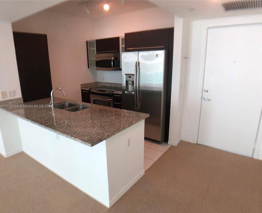 950 Brickell Bay Drive, Unit 602 Miami, FL 33131 - Photo 7 of 20 a kitchen with stainless steel appliances granite countertop a refrigerator and a sink