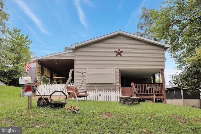 a view of a house with a yard and sitting area