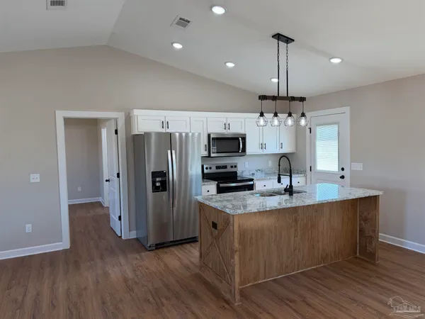 a kitchen with stainless steel appliances a sink refrigerator and microwave