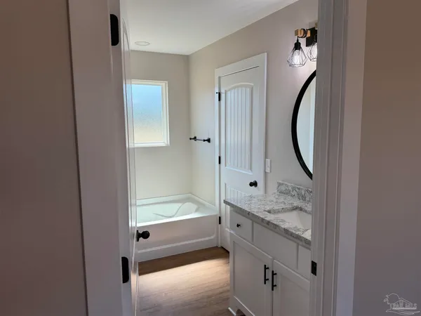 a bathroom with a granite countertop sink and a mirror
