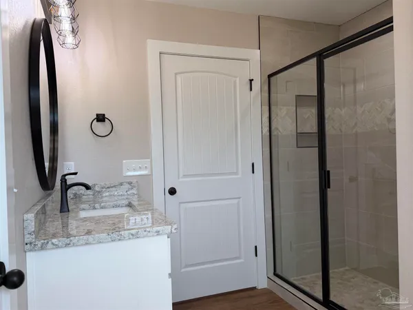 a bathroom with a granite countertop shower sink and vanity