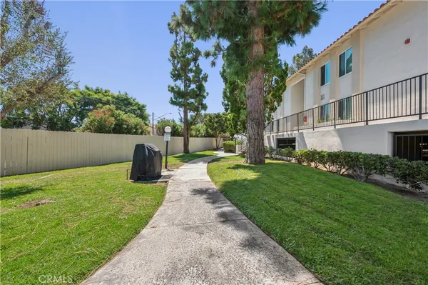 a view of an house with backyard and a tree