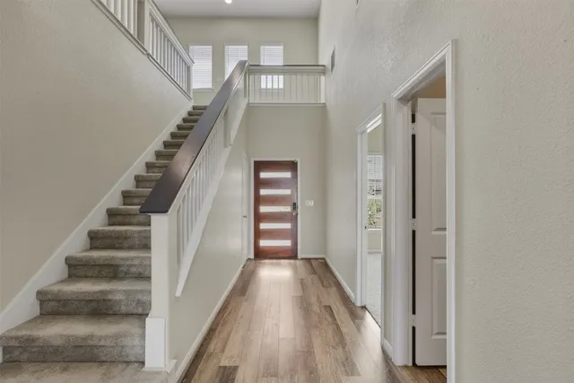 a view of a hallway with wooden floor and entryway