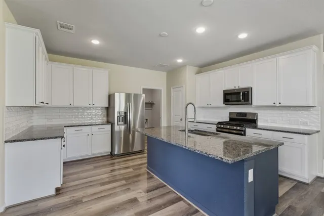 a kitchen with a refrigerator stove microwave and sink