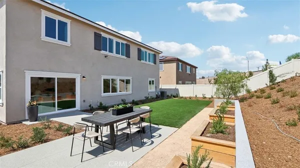 a backyard of a house with table and chairs