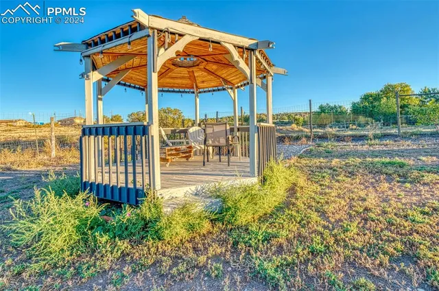 a view of a chairs and table on the wooden deck