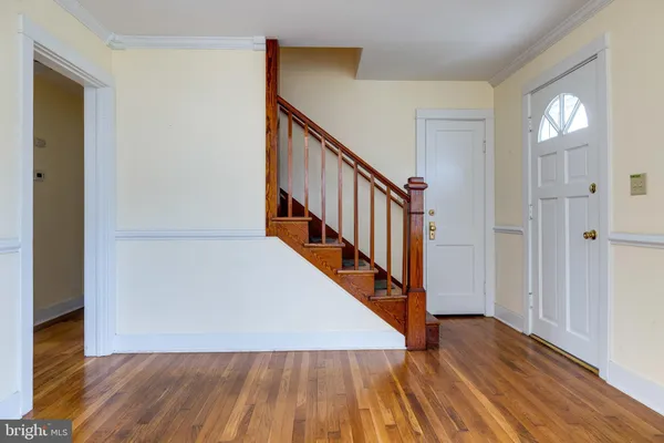 a view of a hallway with wooden floor and staircase