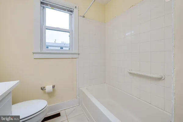 a bathroom with a tub a toilet and a window