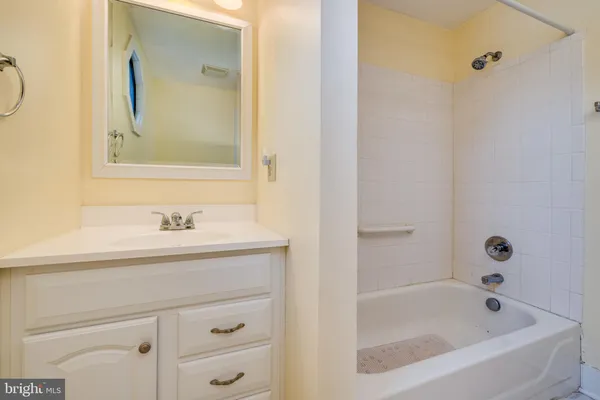 a bathroom with a granite countertop sink mirror and a bathtub