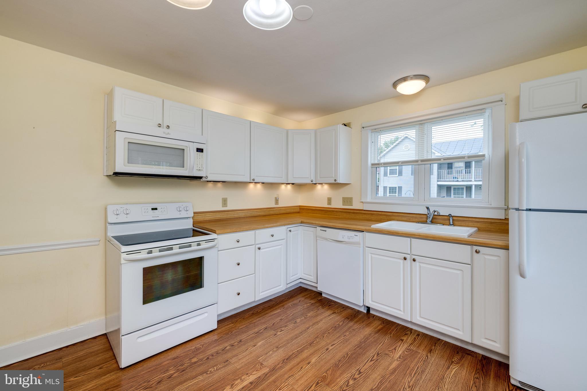 220 Mechanic Street Luray, VA 22835 - Photo 4 of 45 a kitchen with granite countertop white cabinets and white appliances