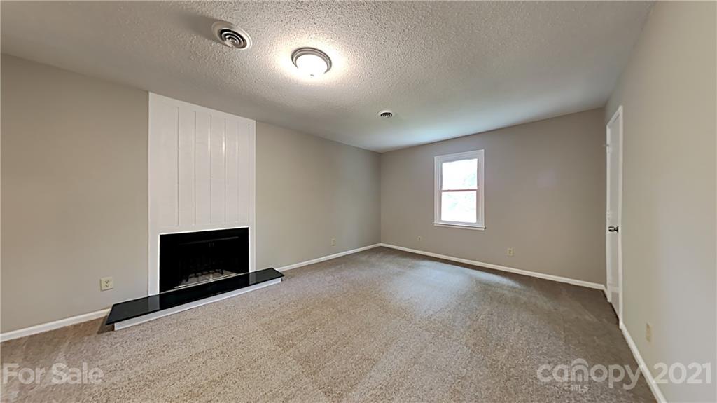 1606 Willowbrook Drive Fort Mill, SC 29708 - Photo 7 of 12 an empty room with a fireplace and windows