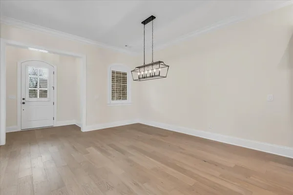 a view of a livingroom with wooden floor a ceiling fan and windows