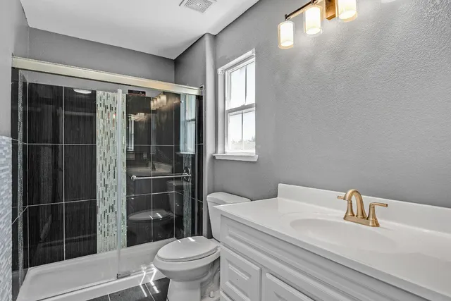 a bathroom with a sink a toilet and shower