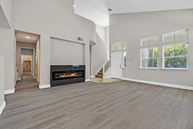 a view of a livingroom with wooden floor and a fireplace