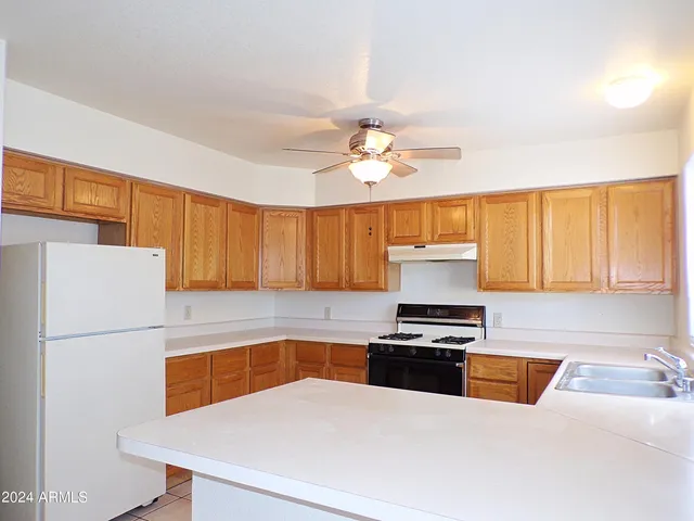 a kitchen with granite countertop a refrigerator a stove and a sink