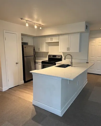 a kitchen with refrigerator and cabinets