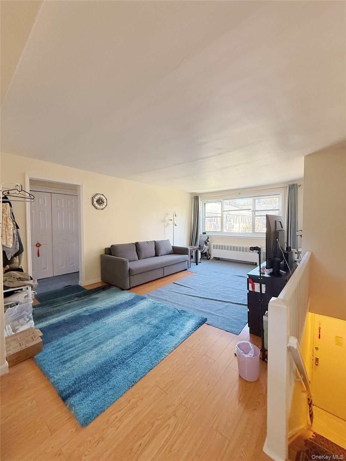 152-47 Jewel Avenue, Unit 159B Queens, NY 11367 - Photo 11 of 11 a living room with furniture and a wooden floor