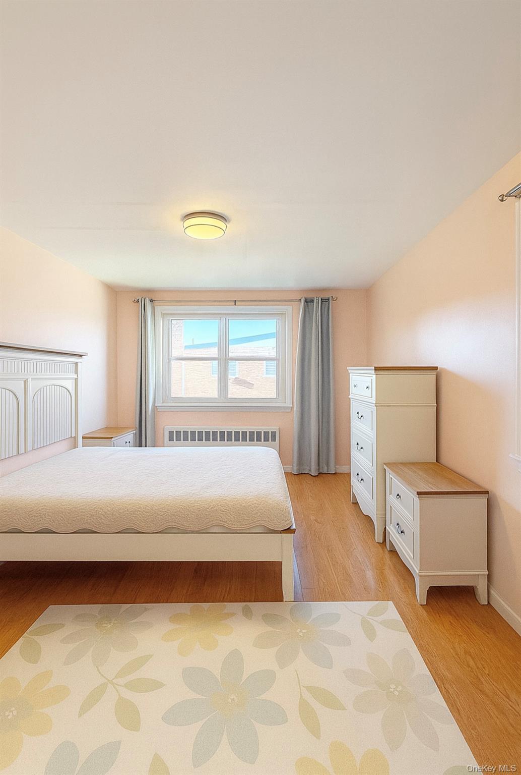 152-47 Jewel Avenue, Unit 159B Queens, NY 11367 - Photo 4 of 11 a bedroom with a large bed and white walls