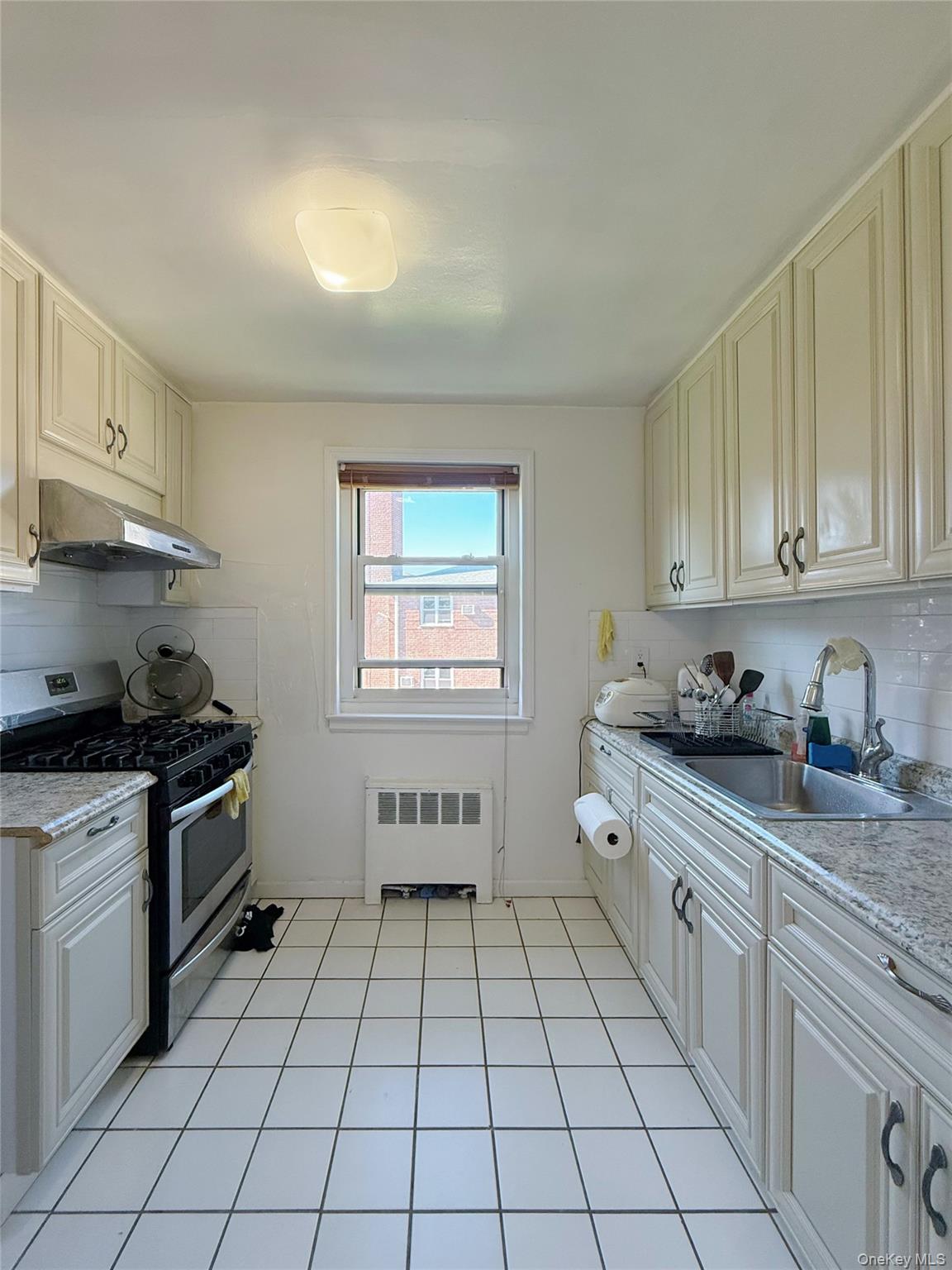 152-47 Jewel Avenue, Unit 159B Queens, NY 11367 - Photo 8 of 11 a kitchen with stainless steel appliances granite countertop a stove a sink and a refrigerator