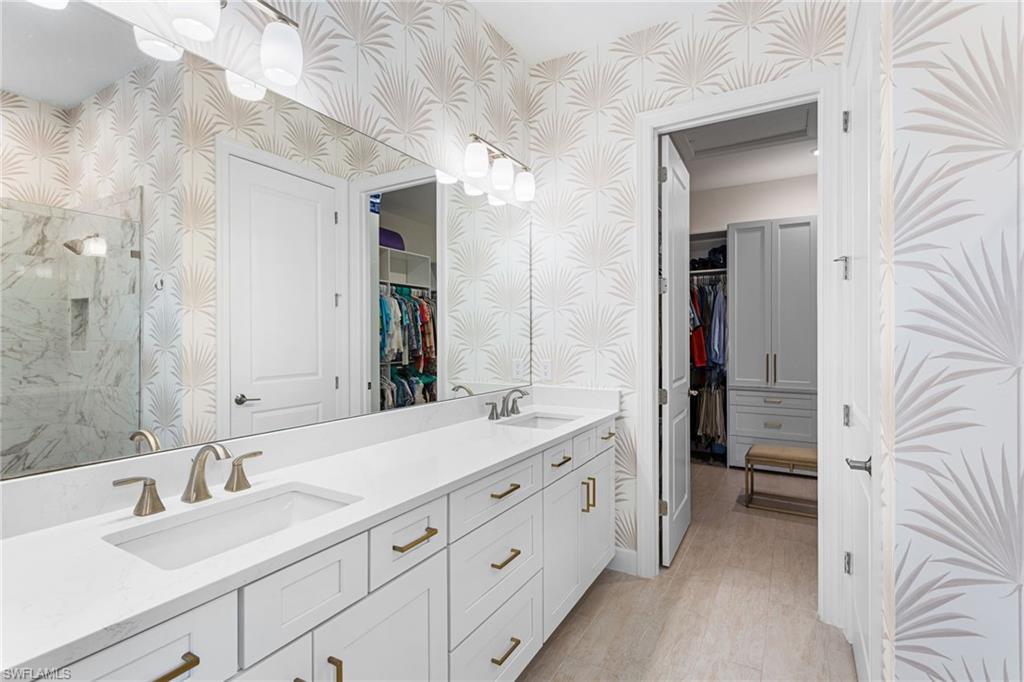 15216 Turin Drive Naples, FL 34114 - Photo 19 of 50 Bathroom with a spacious closet, wallpapered walls, double vanity, and a marble finish shower