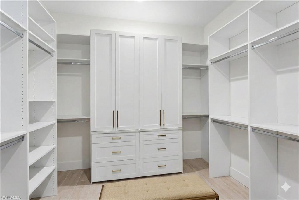 15216 Turin Drive Naples, FL 34114 - Photo 21 of 50 Walk in closet with light wood-style floors