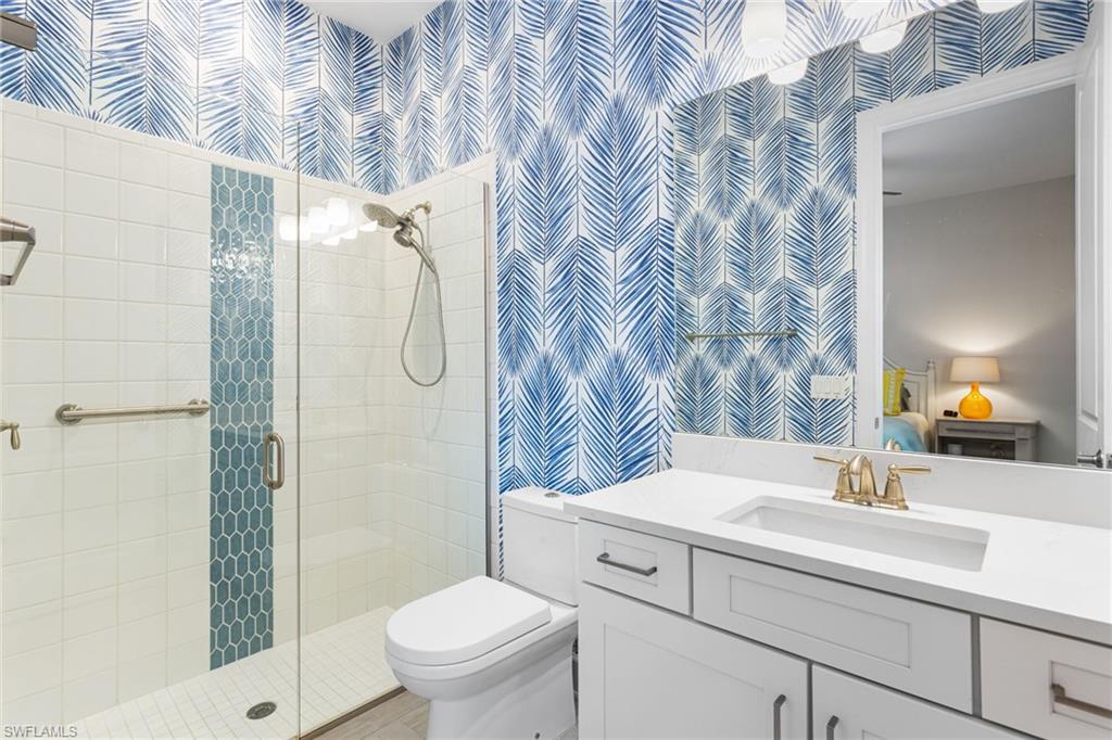 15216 Turin Drive Naples, FL 34114 - Photo 26 of 50 Full bath with wallpapered walls, vanity, a stall shower, and connected bathroom