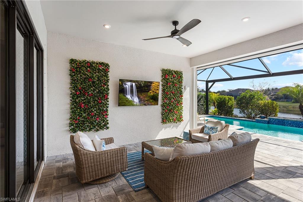 15216 Turin Drive Naples, FL 34114 - Photo 3 of 50 View of patio with an outdoor pool, a sunroom, glass enclosure, a ceiling fan, and outdoor seating