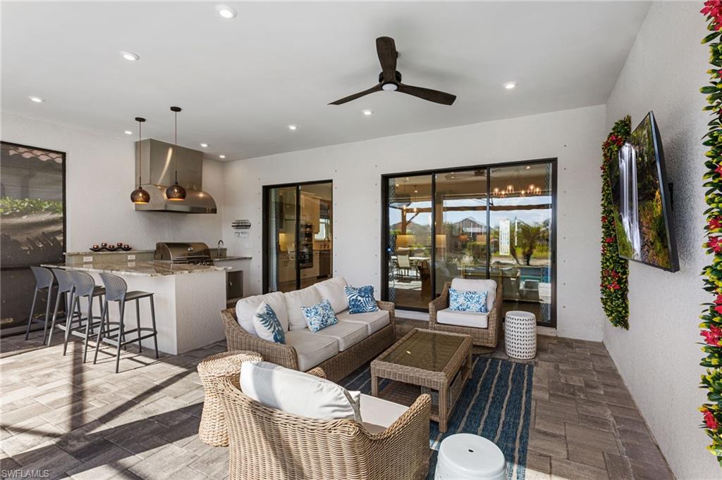15216 Turin Drive Naples, FL 34114 - Photo 30 of 50 View of patio / terrace featuring area for grilling, ceiling fan, and an outdoor lounge area with bar