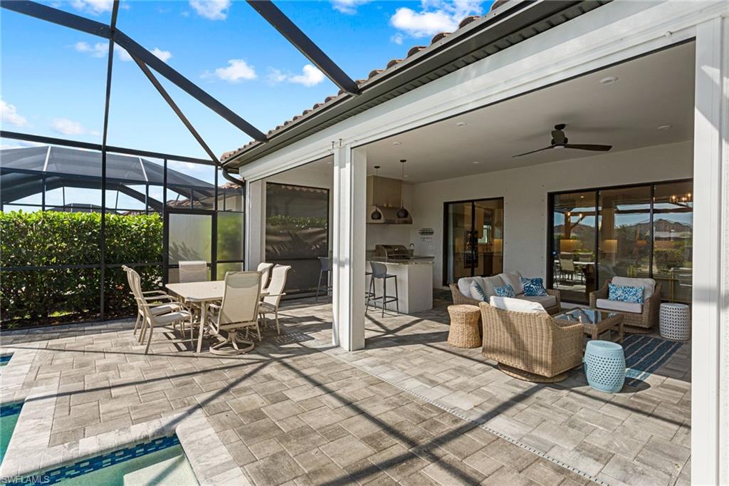 15216 Turin Drive Naples, FL 34114 - Photo 32 of 50 View of patio / terrace featuring a lanai, an outdoor living / dining area, ceiling fan, a sunroom, and area for grilling