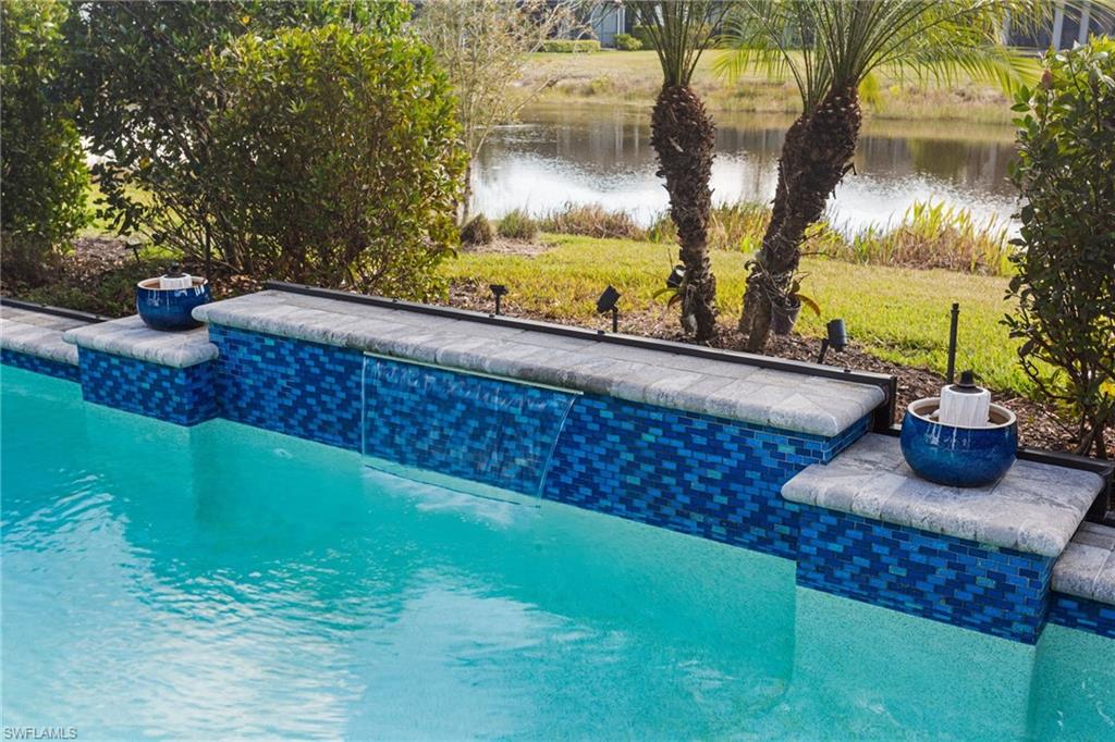 15216 Turin Drive Naples, FL 34114 - Photo 33 of 50 Outdoor pool with a water view, a patio, and a lawn
