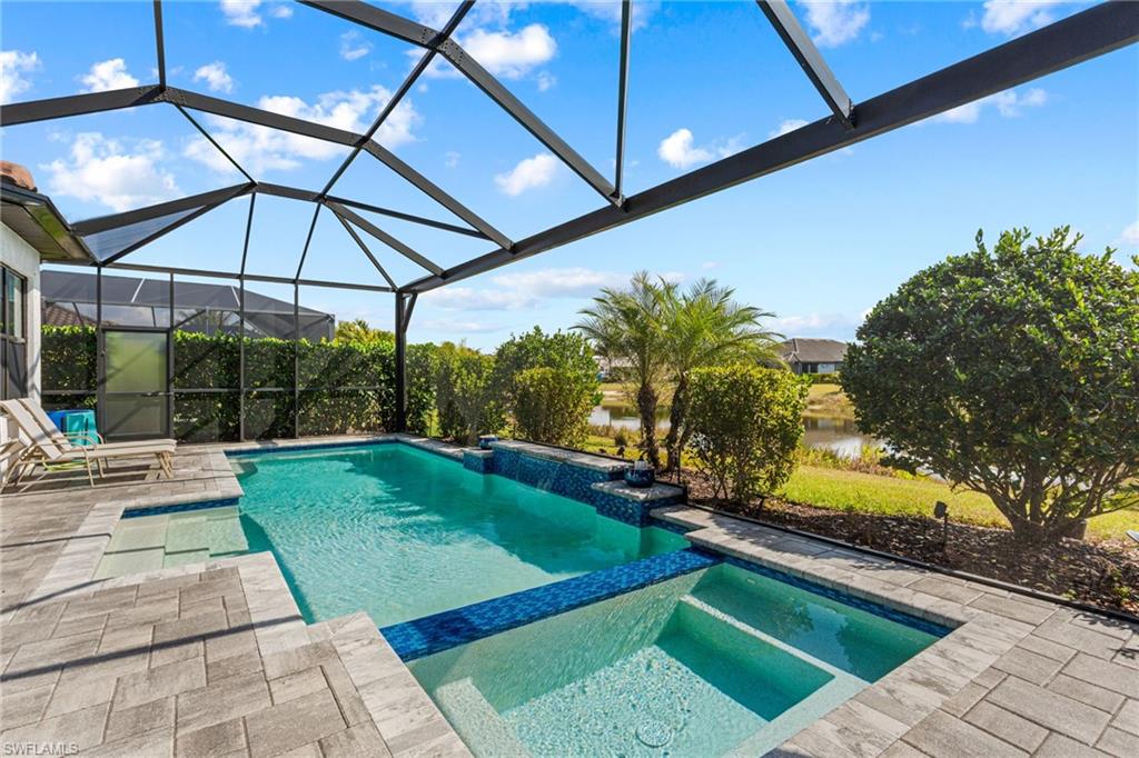 15216 Turin Drive Naples, FL 34114 - Photo 34 of 50 Integrated pool / spa featuring a patio, a lanai, a water view, and a sunroom