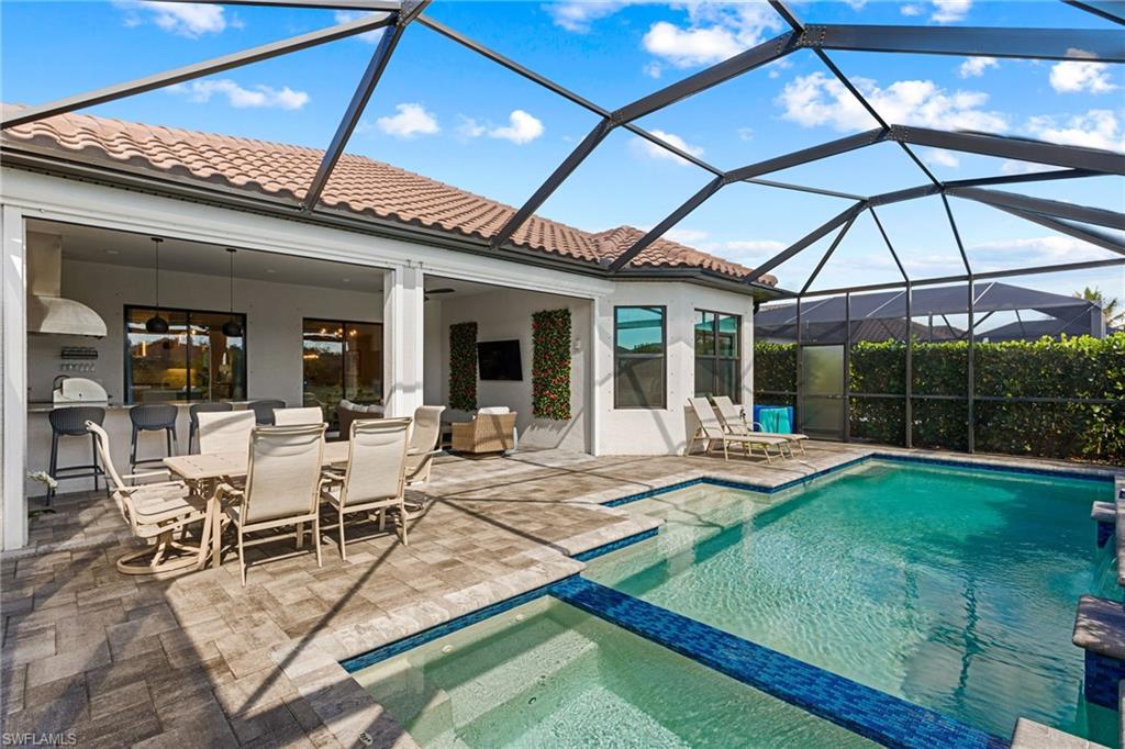 15216 Turin Drive Naples, FL 34114 - Photo 35 of 50 Relaxing pool / spa featuring a sunroom, a lanai, outdoor dining area, and a patio