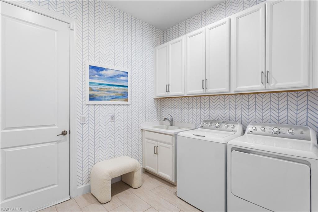 15216 Turin Drive Naples, FL 34114 - Photo 38 of 50 Laundry room featuring wallpapered walls, independent washer and dryer, and cabinet space