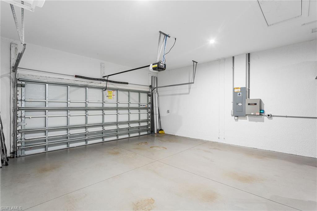 15216 Turin Drive Naples, FL 34114 - Photo 39 of 50 Garage with electric panel and a garage door opener
